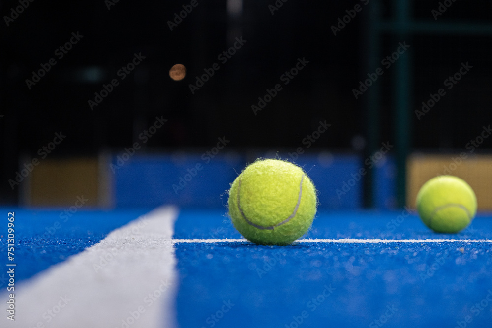 two ball on a paddle tennis court at night