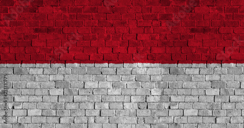 Principality of Monaco Flag Over a Grunge Brick Background photo