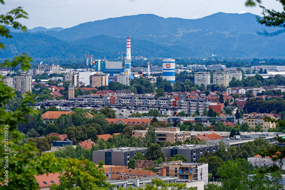 Aerial view of City of Ljubljana with skyline and skyscrapers seen from castle hill with mountain panorama in the background on a cloudy summer day. Photo taken August 9th, 2023, Ljubljana, Slovenia.