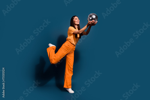 Full body size photo of young hispanic clubber woman standing one leg demonstrate glitter disco ball isolated on dark blue color background