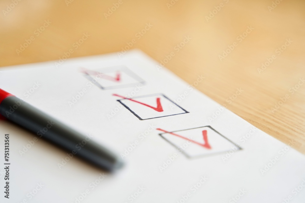 Checklist marked red with a red pen. Close up shot of filled check boxes with red pen Checklist marked red with a red pen. Close up shot of filled check boxes with red pen
