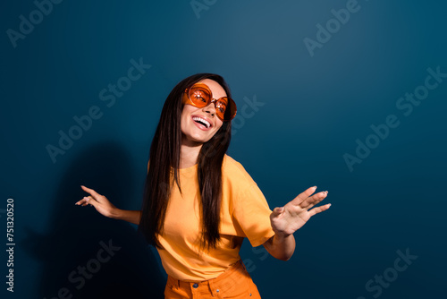 Portrait of gorgeous adorable fancy woman wear stylish t-shirt in sunglass dancing at night club isolated on dark blue color background.