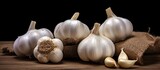 Several heads of garlic are neatly arranged on top of a rustic wooden table, creating a simple and practical display of this versatile ingredient commonly used in cooking.
