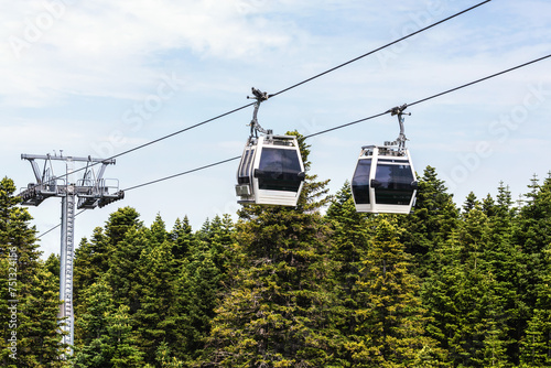 Cable cars ascend and descend on steel cables above a lush forest on Mount Uludag. Teleferik (funicular) in Bursa, Turkey (Turkiye)