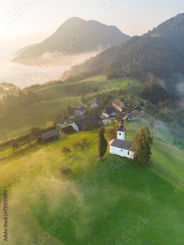 3 October 2023, Sveti Tomaž Church, Škofja Loka, Slovenia; Aerial drone shots of the church at sunrise on a misty autumn morning