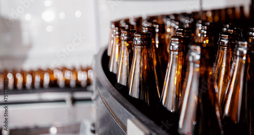 Brown glass beer drink alcohol bottles  brewery conveyor  modern industrial food production line banner with sunlight