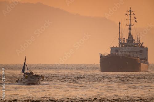 朝日照らす関門航路で近づく漁船と貨物船20240212-1 photo