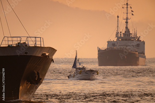 朝日照らす関門航路で近づく漁船と貨物船20240212-2 photo