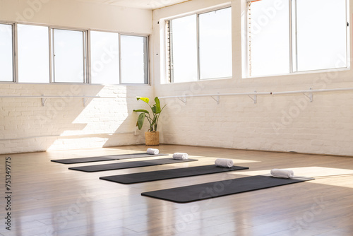 A serene yoga studio awaits practitioners, bathed in natural light, with copy space photo