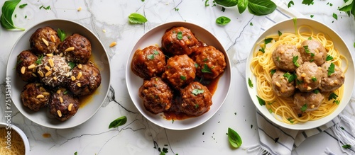 Three plates placed on a table, each filled with spaghetti and meatballs. The classic combination of Italian American flavors is evident in the savory meatballs and tangy tomato sauce smothering the
