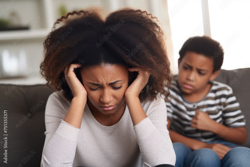 Concerned Single Mother with Son. Stressed African American mother with headache while her son looks on, concerned. Concerned Single Mother with Son. Stressed African American mother with headache while her son looks on, concerned.