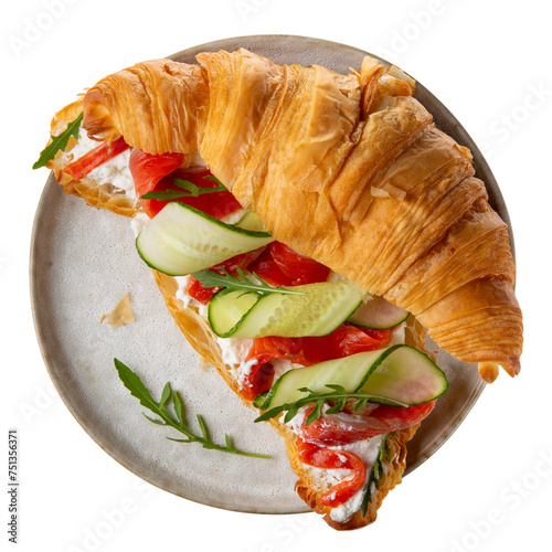 Croissant sandwich with cream cheese, smoked salmon, cucumber and arugula on gray plate isolated on white. Top view. photo
