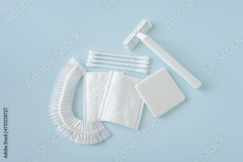 Set of white sanitary or toiletry kit on blue background, top view