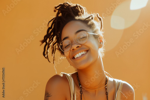 Young beautiful African American woman enjoying sunlight against an orange wall. 