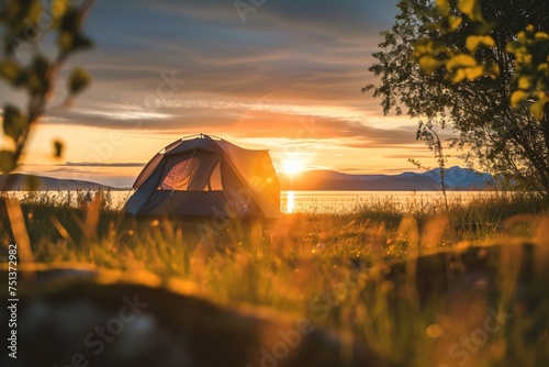 a tent in a field with a sunset