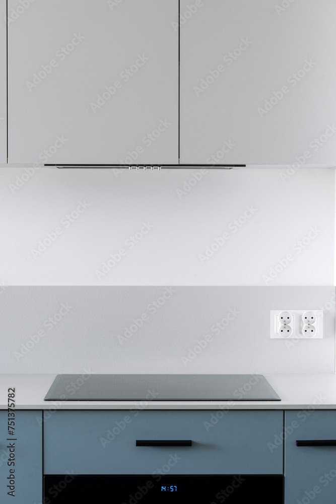 Glass ceramic induction stove and integrated range hood in modern kitchen Glass ceramic induction stove and integrated range hood in modern kitchen