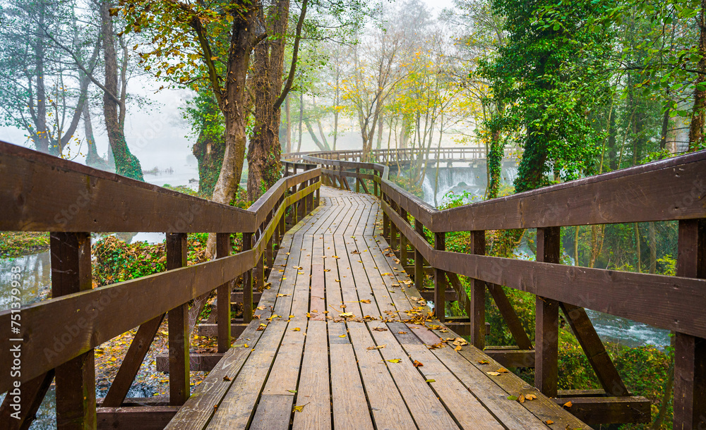 Amazing wooden bridge over the wild lake in Jajce, Bosnia. Wooden bridge walkway on Small Plivsko lake in the morning mist or fog with autumn colours - Park Plivsko Jezero, Bosnia. Amazing wooden bridge over the wild lake in Jajce, Bosnia. Wooden bridge walkway on Small Plivsko lake in the morning mist or fog with autumn colours - Park Plivsko Jezero, Bosnia.