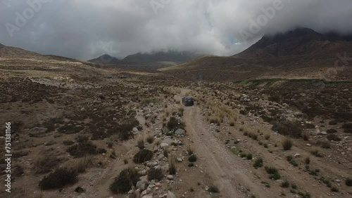 Drone: flies behind a car through a gorge in the mountains of Kyrgyzstan