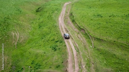 Drone: flies behind a car along the valley of the mountains of Kyrgyzstan