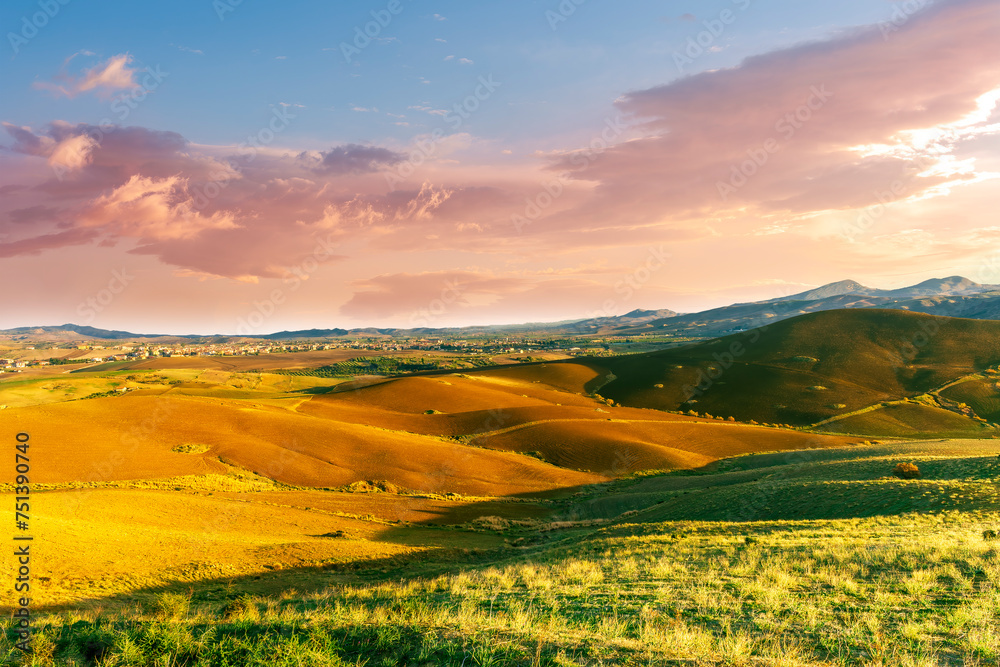 beautiful landscape in a yellow golden field in autumn or summer evening with nice rustic view of hills in countryside