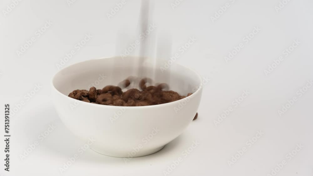 Chocolate rings in white bowl. Healthy meal. Nutritious breakfast on white background. Brown chocolate breakfast rings. Preparing of sweet breakfast consisting of cornflakes. Chocolate rings in white bowl. Healthy meal. Nutritious breakfast on white background. Brown chocolate breakfast rings. Preparing of sweet breakfast consisting of cornflakes.