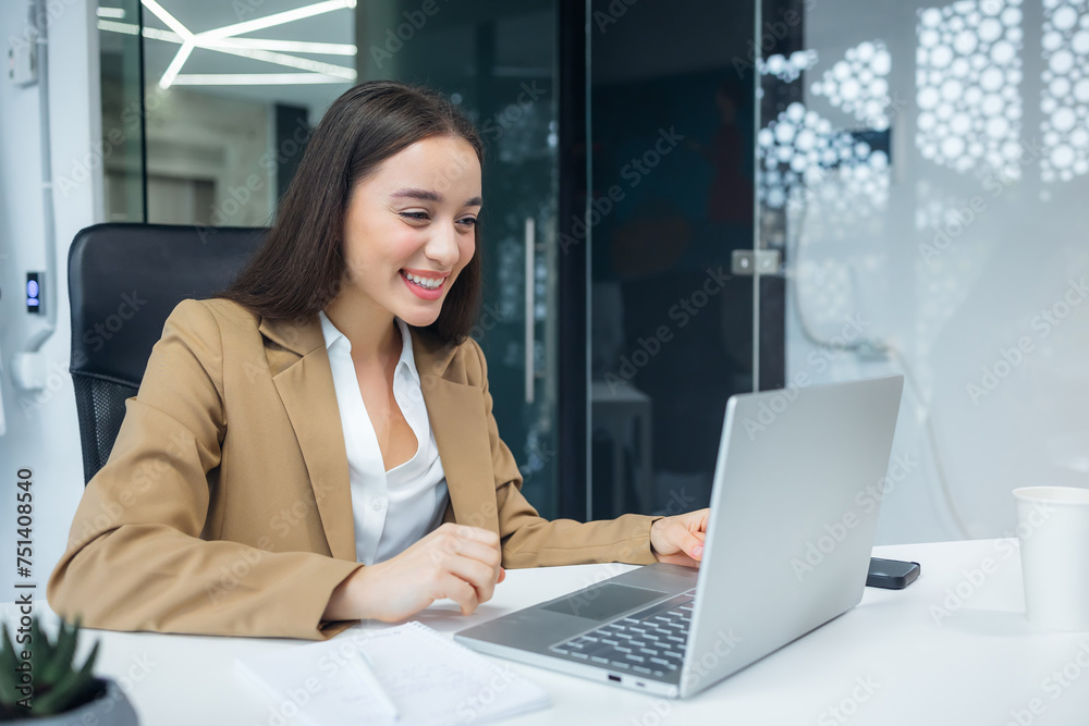 Young and happy caucasian woman working in modern office using laptop, businesswoman smiling and feeling happy Young and happy caucasian woman working in modern office using laptop, businesswoman smiling and feeling happy