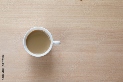 Tazzina bianca con caffè e piattino su tavolo di legno photo