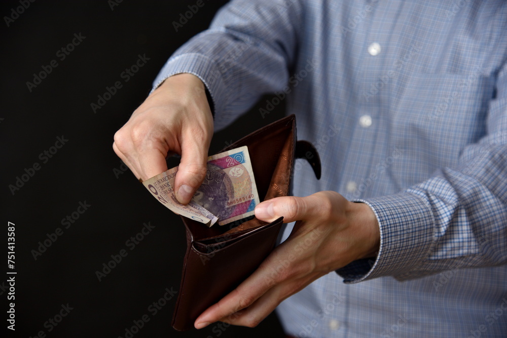 Mezczyzna trzymajacy polskie banknoty, gotowka w portfelu. - obrazy, fototapety, plakaty 