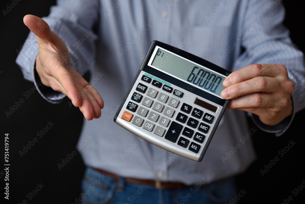 Businessman holding calculator with 60000 value on it, black background. Businessman holding calculator with 60000 value on it, black background.