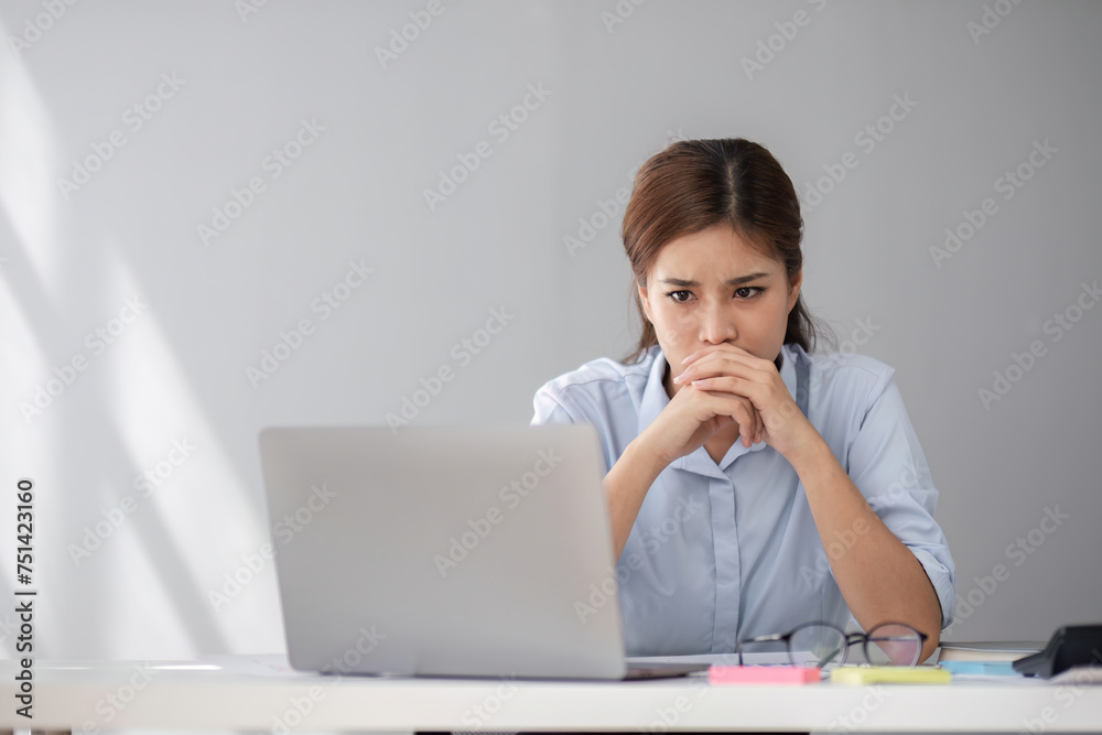 Young business woman with stress working in the office Sitting and working in front of a laptop, discussing work that is having problems. Young business woman with stress working in the office Sitting and working in front of a laptop, discussing work that is having problems.
