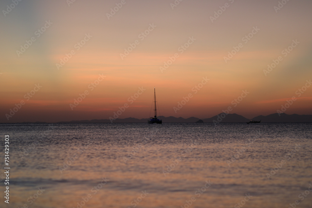 Sailboat in the distance during sunset Sailboat in the distance during sunset