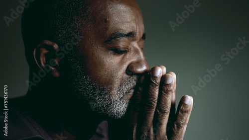 Earnest African American Elder Seeking Divine Guidance in Prayer, Eyes Shut and Hands Together, Senior Man in Deep Contemplation Asking for Help and Support