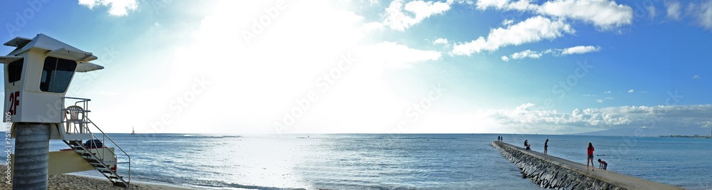 Ocean, blue sky and people at beach for adventure, sunshine and travel on natural background or landscape. Sea, fresh air and clouds with calm water, vacation destination or location for tourism