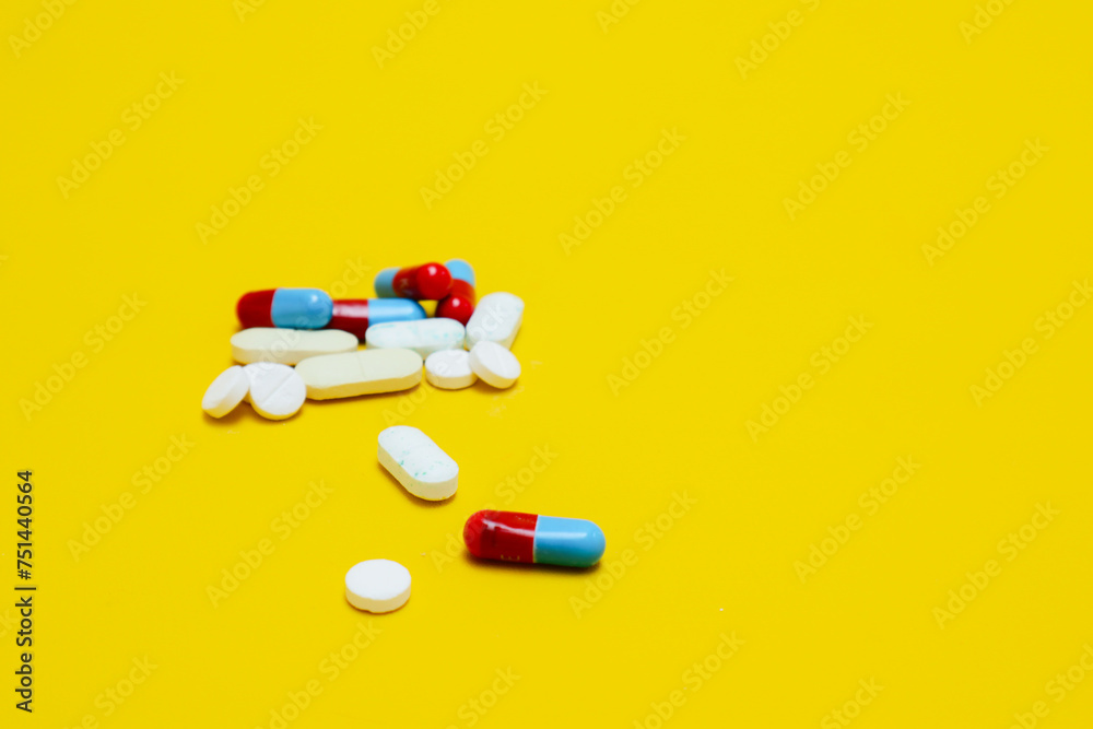 photo of medicine capsules and tablets isolated on yellow background photo of medicine capsules and tablets isolated on yellow background