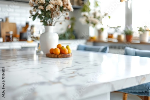 A white marble countertop with a vase of flowers and a tray of oranges © Aliaksandr Siamko