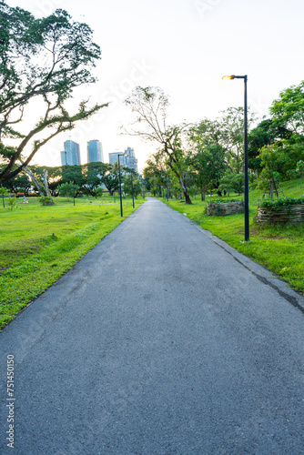 Green city park with sunset blue sky cloud pathway and beautiful trees track running walking relax in park