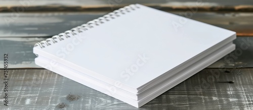 Blank white notebook with empty pages on a rustic wooden table for writing or sketching ideas and notes