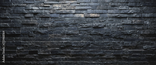 Background and texture of black blue stone brick with light illuminated in places. Panorama. photo