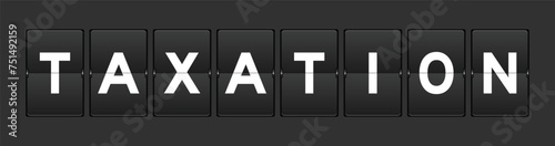 Black color analog flip board with word taxation on gray background