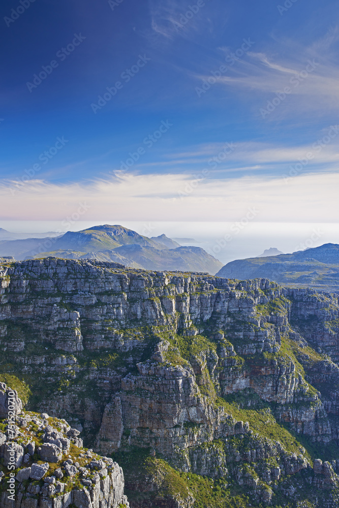 Mountains, landscape and clouds in sky for travel, hiking or eco friendly tourism by ocean or sea on horizon. Aerial view of environment, nature and rock texture or mockup in Cape Town, South Africa
