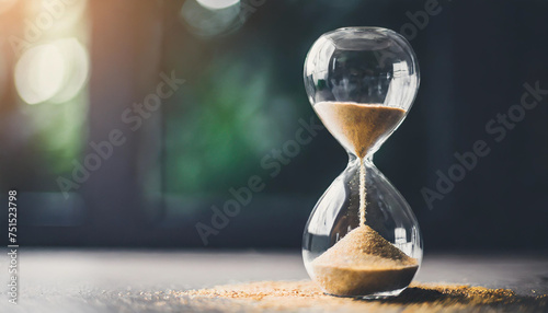 Hourglass with sand slipping through, measuring time's passage. Countdown concept photo