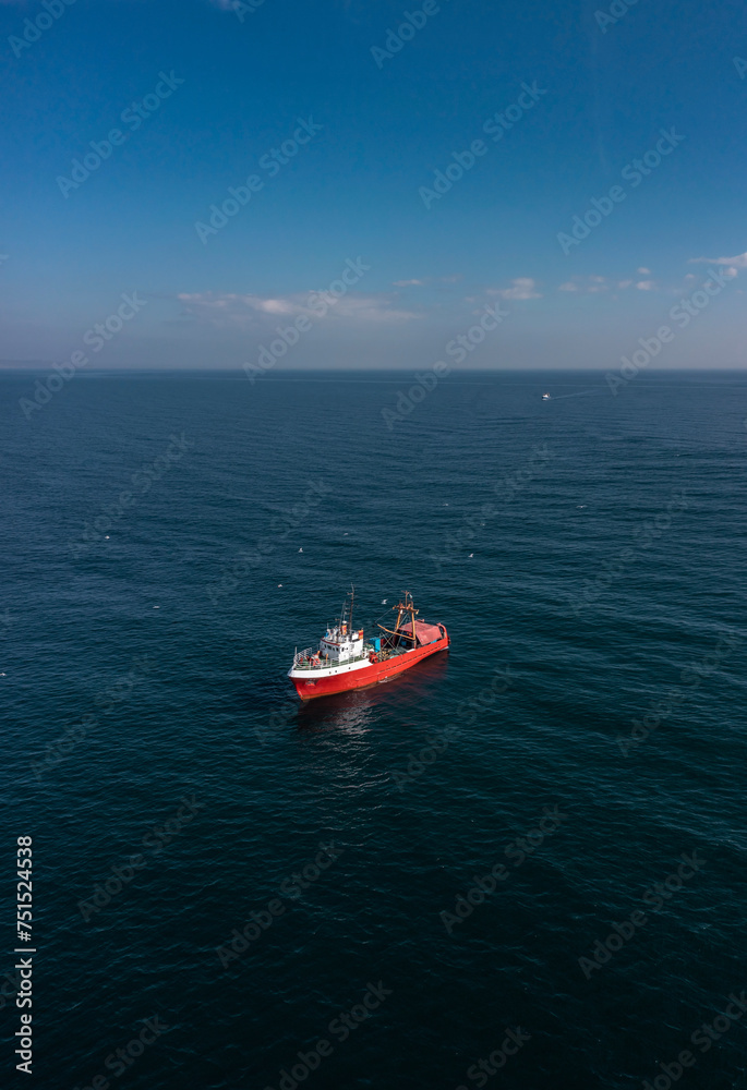Aerial view to a red fishing vessel in sea Aerial view to a red fishing vessel in sea