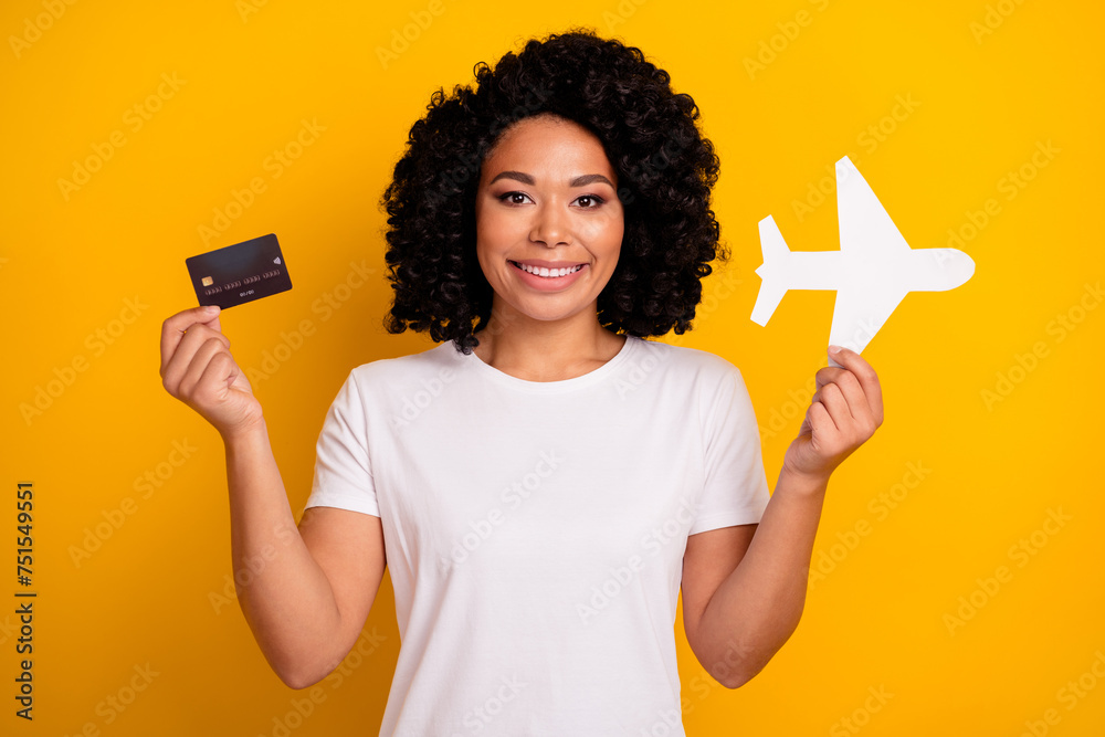 Photo of positive excited woman wear white t-shirt buying online plane tickets isolated yellow color background Photo of positive excited woman wear white t-shirt buying online plane tickets isolated yellow color background