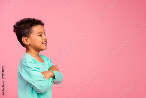 Photo portrait of charming small boy folded hands look empty space wear trendy aquamarine outfit isolated on pink color background