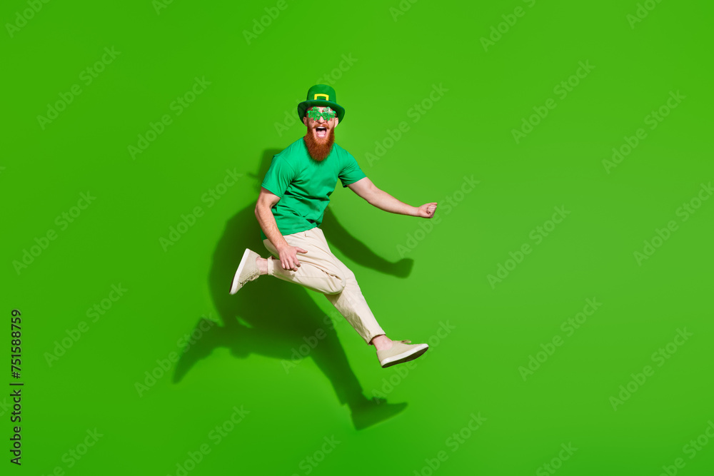 Full body profile portrait of carefree person jump raise fist rejoice empty space isolated on green color background - obrazy, fototapety, plakaty 