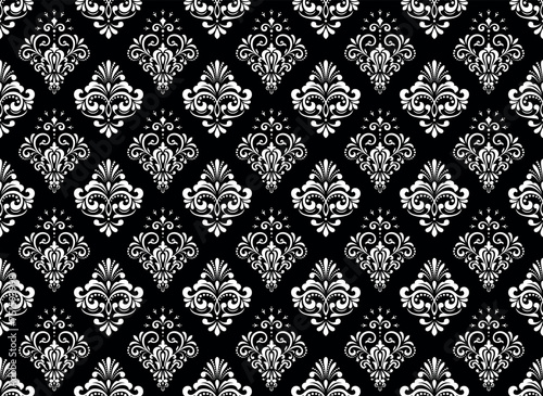 Wallpaper in the style of Baroque. Seamless vector background. White and black floral ornament. Graphic pattern for fabric, wallpaper, packaging. Ornate Damask flower ornament