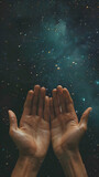 Hands open in supplication under a starry night sky