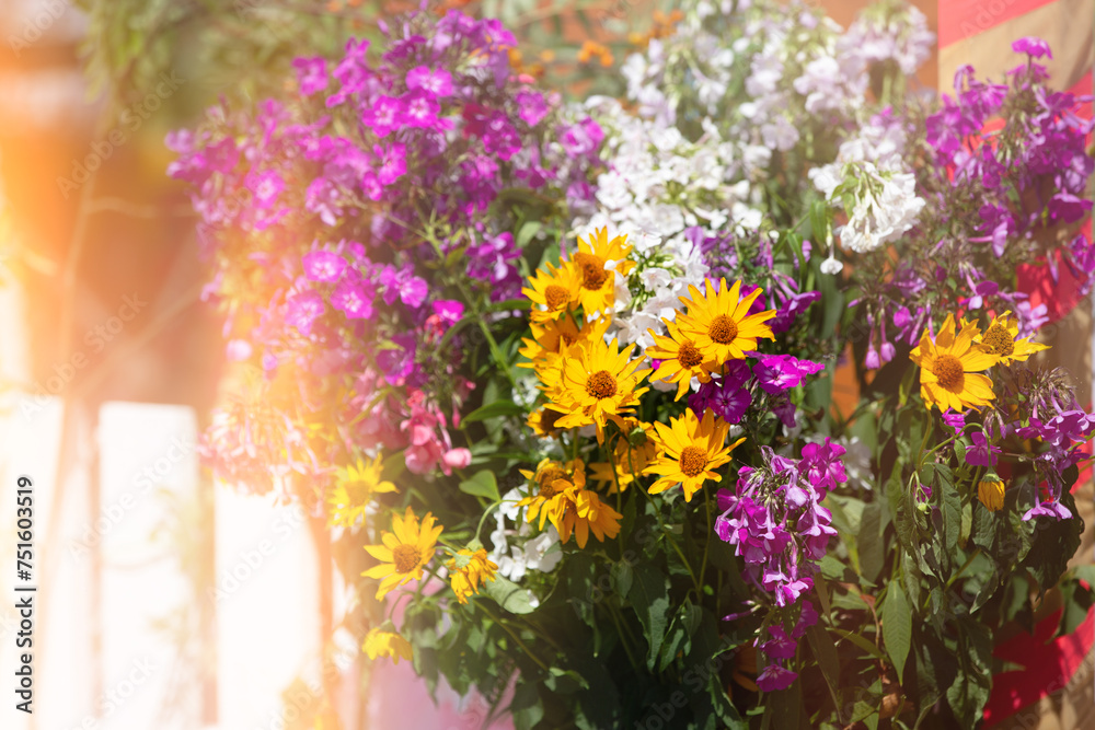 Obraz premium Floral background of a bouquet of chrysanthemums and petunias in a yellow haze.