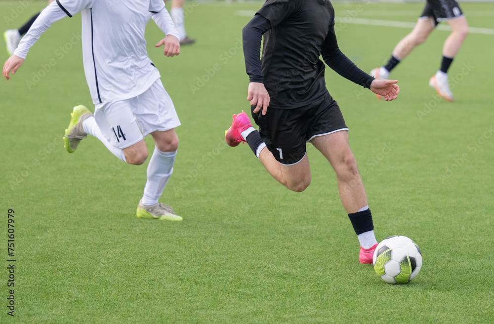 Fußballspieler, die dem Ball hinterherlaufen Fußballspieler, die dem Ball hinterherlaufen