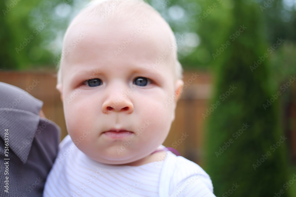Closeup portrait of little cute baby on shoulder of parent, close up view, focus on nose Closeup portrait of little cute baby on shoulder of parent, close up view, focus on nose